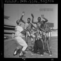 John Werhas shooting basketball as three Globetrotters play defense on infield of Dodgers Stadium, 1964