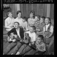 Singing group, the Singing Lennon Sisters, sitting on couch with seven younger siblings in Venice, Calif., 1964