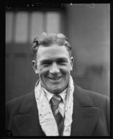 Football player Ernie Nevers smiling in front of Southern Pacific train, California, 1930-1939 (?)