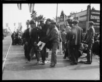 Spectators carrying a wounded woman at the Tournament of Roses Parade, Pasadena, 1926