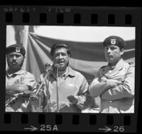 Cesar Chavez flanked by two Brown Berets, speaking at Los Angeles peace rally, 1971