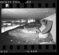 Illegal immigrant squatter on mattress under freeway in Los Angeles, Calif., 1986