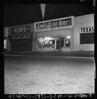 Police officers guard a looted store in Watts, Los Angeles (Calif.)