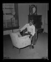 Ice Cream salesman Mark Marlatt, with chair purchased at Hollywood Hotel closing auction, 1956