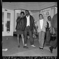 African American youths pose by damaged storefronts in Watts, Los Angeles (Calif.)