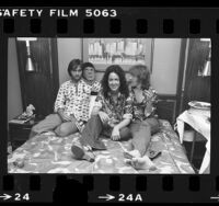 Marty Balin, Grace Slick, and Paul Kantner of Jefferson Starship seated on hotel room bed in Los Angeles, Calif., 1976