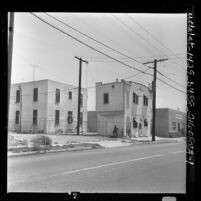 African American family outside apartment house at 32nd Street in Los Angeles, Calif., 1962