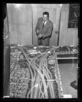 Engineer Heinz Heckeroth points out features on model of Southern California freeways, 1958