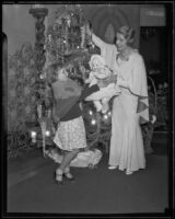 Aimee Semple McPherson gives a doll to a little girl for Christmas present, Los Angeles