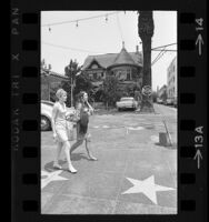 Two women walking past Victorian house of Misses Janes School at 6541 Hollywood Blvd., Hollywood (Los Angeles) 1967