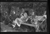 Harriet A. McCabe poses in garden with part of doll collection to be donated, Pasadena, 1935