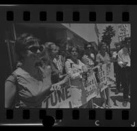 Protesters holding signs after being arraigned as a result of a clash at a demonstration at Century Plaza during President Johnson's visit, 1967