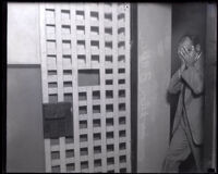 Dr. Helon B. Allen shields face in jail holding cell, Los Angeles, 1923