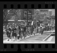 Demonstrators walking along sidewalk during Mother's Day anti-war march in Los Angeles, Calif., 1970