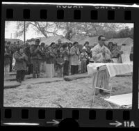 Buddhist priest Tri Sanh leading Vietnamese refugees in prayer at Camp Pendleton, Calif., 1975