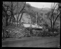 Man and boy stand at ruins of home destroyed by the Sunset Canyon fire, Los Angeles, 1927