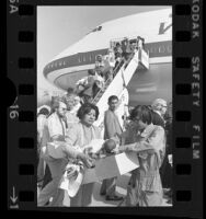 South Vietnamese and Cambodian orphaned infants being carried in cardboard boxes off plane at Los Angeles International Airport, Calif., 1975