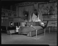 Woman kneels in front of the Pasadena display at the National Orange Show, San Bernardino, 1935