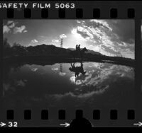 Couple of horseback riding through rain puddles in Griffith Park, Los Angeles, 1977