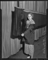 Harriet Jordan points to fire damage at Angelus Temple, Los Angeles, 1935