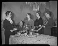 Five members of the Women's Auxiliary of the California Babies Hospital surround a dining room table, 1936