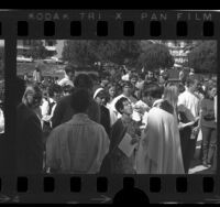 Loyola University president Reverend Donald P. Merrifield holding communion for anti-war marchers, Calif., 1970