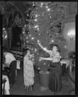 Mrs. Queen Boardman and Lugo Machio decorating Christmas tree, [1934?]