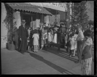 Santa Claus greets children as they line up for the Christmas party hosted by Bozzani Motor Company, Los Angeles, 1935