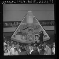 Three students sitting in Apollo spacecraft mockup as William F. Fitzgerald and students watch at Exposition Park in Los Angeles, 1963