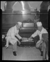 Cooks in the Los Angeles County General Hospital kitchen place a pan of meats into an oven, Los Angeles, [1934]