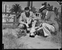 Detectives Thad Brown and Joe Filkas inspect fake bomb, Los Angeles, 1934