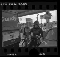 Woman getting gas at an ARCO ampm mini market in Los Angeles, Calif., 1980