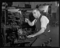 Byron Brainard, newspaper editor and City Council member, seated at a typewriter near a newspaper printing press, Los Angeles, 1935