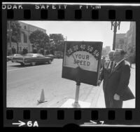 Mayor Sam Yorty and engineer S.S. Taylor demonstrating radar speed meter in Los Angeles, Calif., 1972