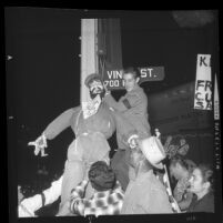 Protesters hanging effigy of Fidel Castro on street sign at Hollywood Blvd. and Vine St., Los Angeles, 1961