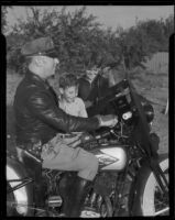 Motorcycle Officer Frank Conkey shows new radio receiver to Dave Harris and Jack Johnson, Los Angeles, 1935