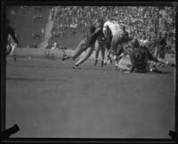 Two USC Trojans try to tackle Utah's No. 45 as he runs with the ball during the USC and Utah football game, Los Angeles, 1932