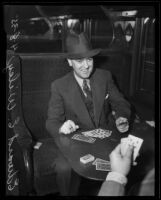 Attorney Edward E. Wiley plays cards on a train on his way to prison, Los Angeles, 1935