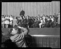 Composer John Philip Sousa onstage with school orchestra and school officials, Philharmonic Auditorium, Los Angeles, 1926