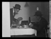 Two detectives search for evidence in the apartment of confessed kidnapper and murderer William Edward Hickman, Los Angeles, 1927