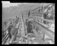 Workmen cleaning up the rubbish and bottles in the stands after a football game at Los Angeles Coliseum