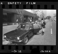 Chauffeur, Mary McCullough, opening door of an Austin Marina for London Towne Livery's Gerald Peters in Beverly Hills, Calif., 1973