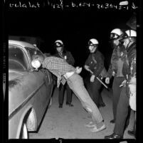 Police in riot gear arresting man during the Isla Vista riots near UC Santa Barbara, 1970