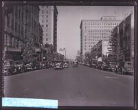 Christmas trees and automobiles lining a street on a commercial street, Los Angeles, circa 1928