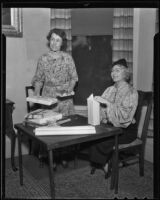 Daughters of the American Revolution members Mrs. George Craig and Nelle Holbrook wrap presents, 1936