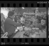 Kyu Chang Lee, waiting on young customers in his Central Avenue grocery in Los Angeles, Calif., 1986