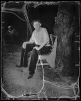 T. C. Naramore seated on a park bench after losing part of his front yard, Los Angeles, 1936