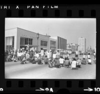 Anti-war demonstrators sitting across Wilshire Blvd. during protest in Los Angeles, Calif., 1972