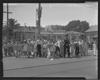 Students crossing the street with officer Ivan E. Crooks on the first day back to school, Montebello, 1935