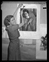 Otis Art Institute student mounting a charcoal drawing on a wall, Los Angeles, 1933